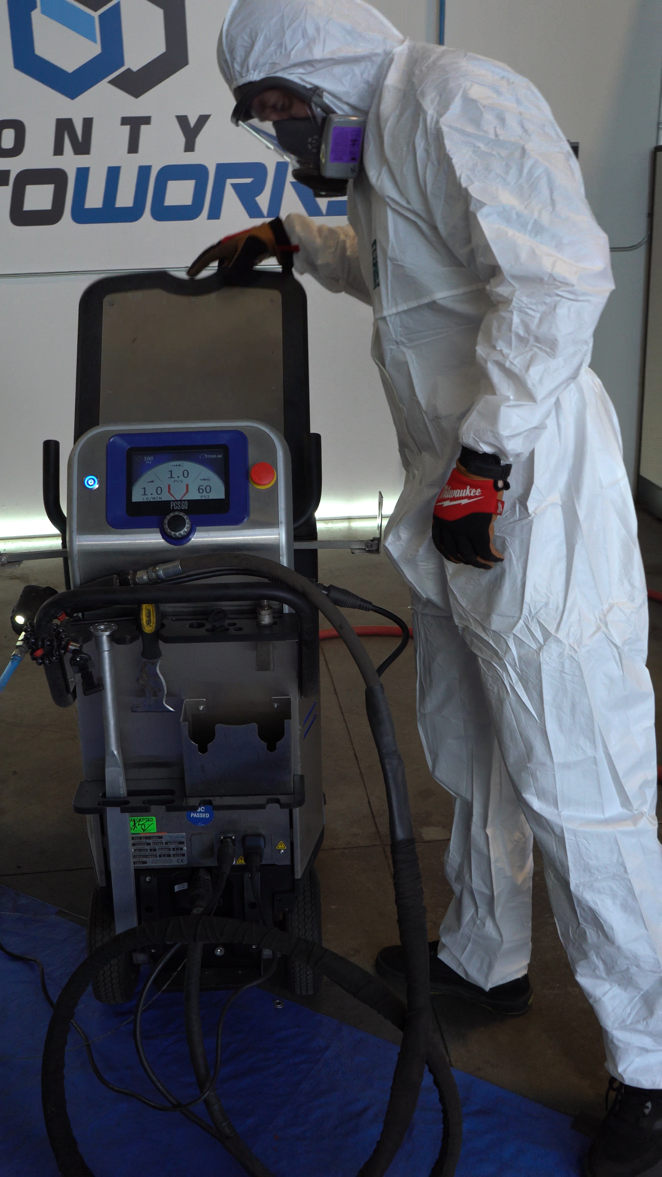 Technician in a hazmat suit operating the machine